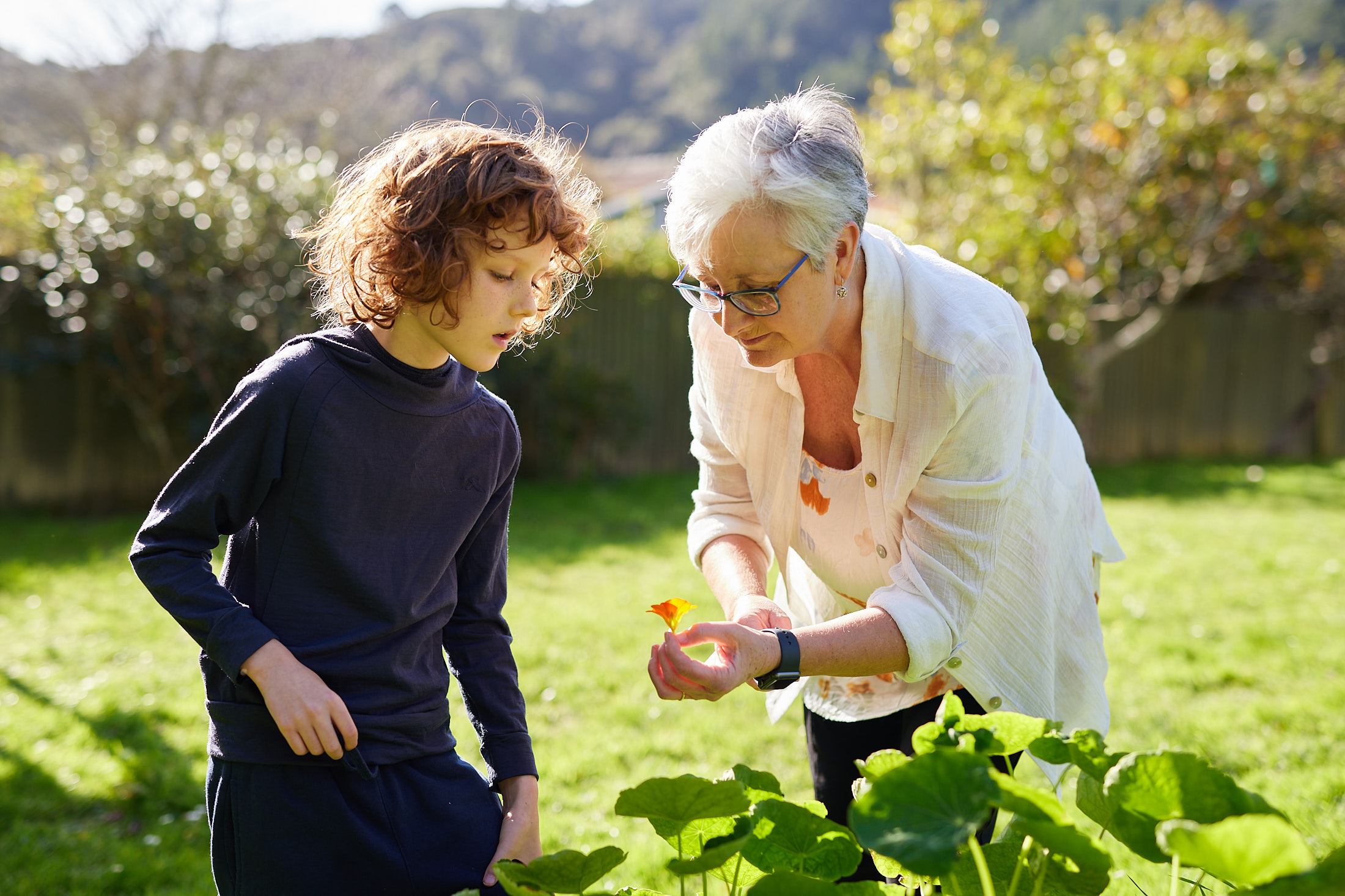 a woman and a child picking flowers in the garden