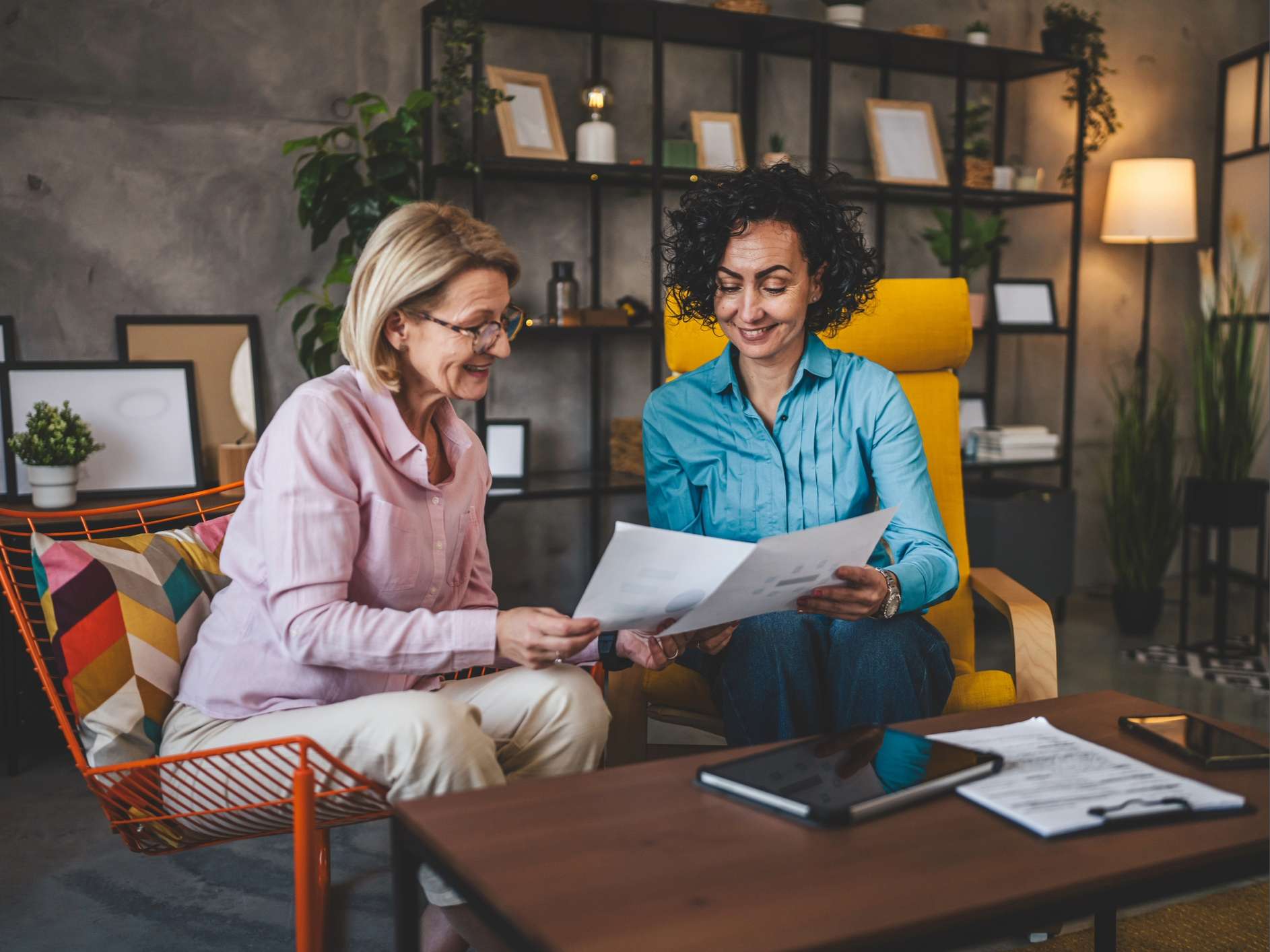 two women sitting by a table discussing
