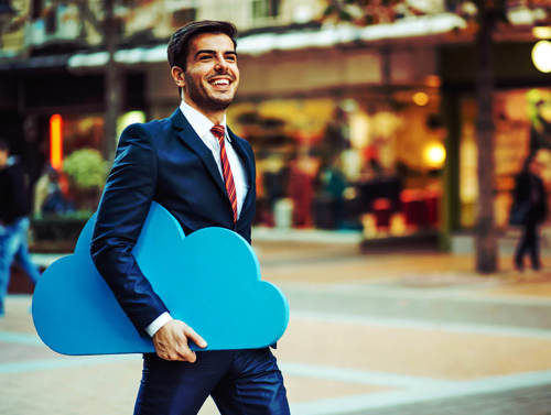 Happy business man walking through a mall with a Blue cloud tucked under his arm indicating the mobility that utilising cloud provides