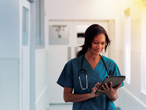 a doctor in scrubs checks her clip board