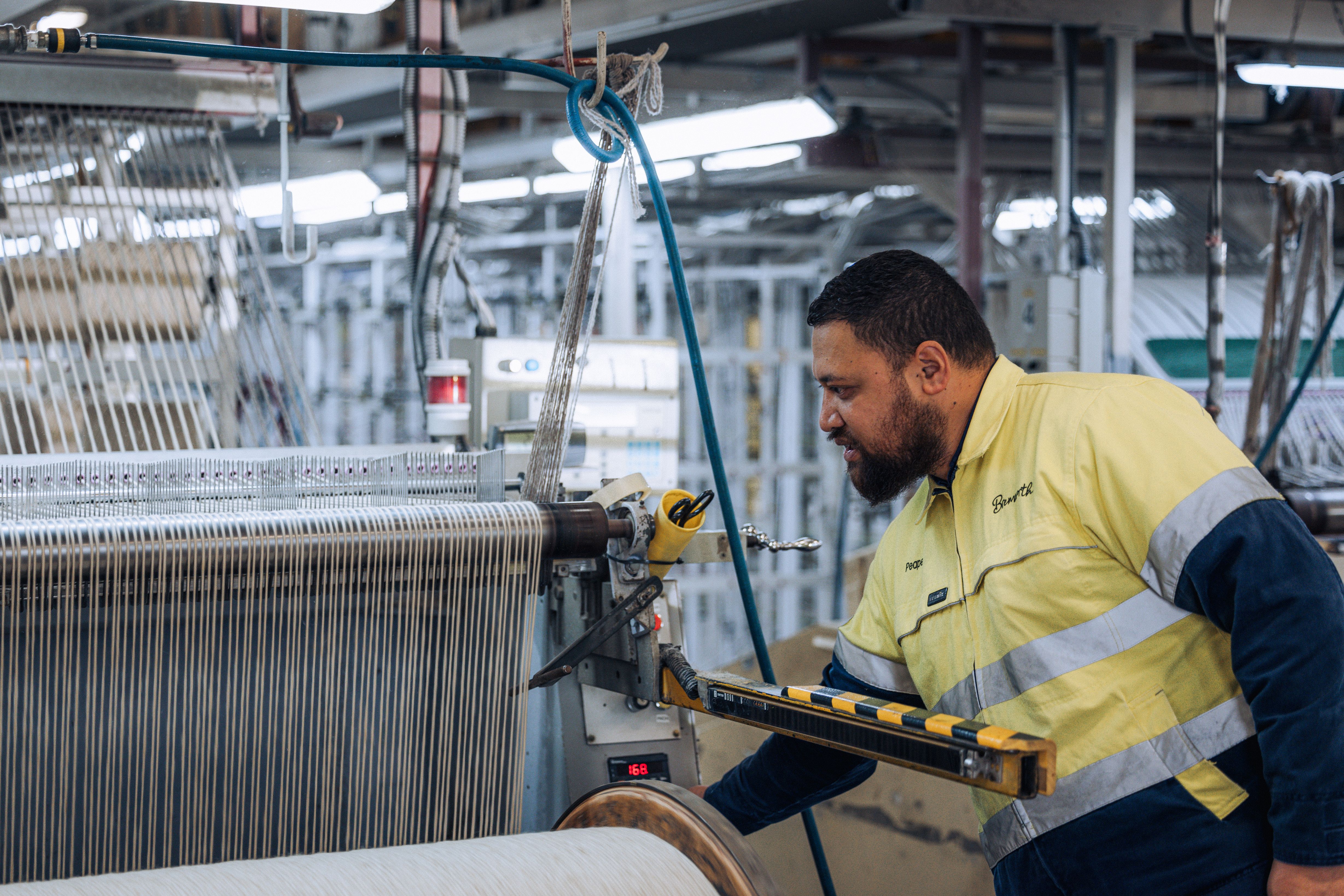 a man in a factory making a carpet