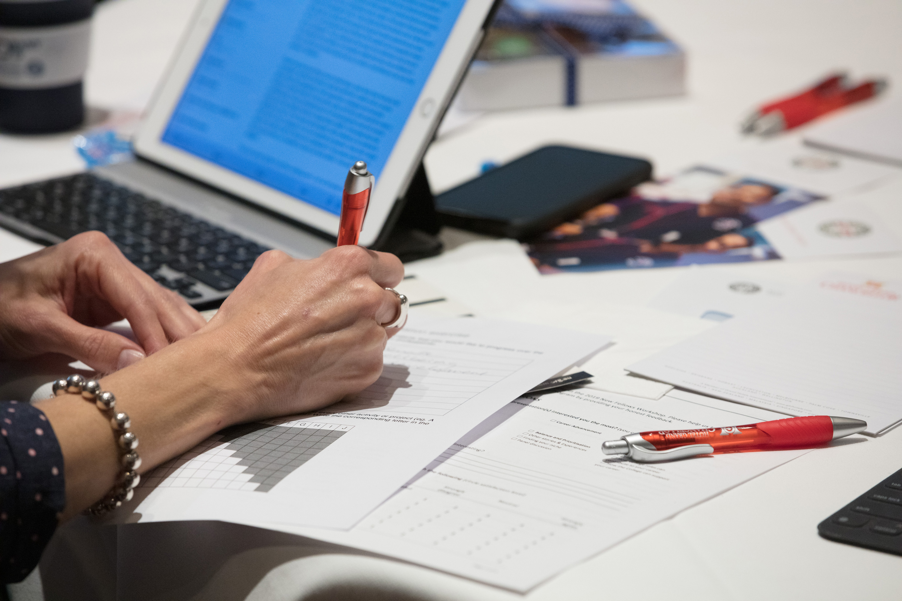 a woman working at her desk with pen and paper